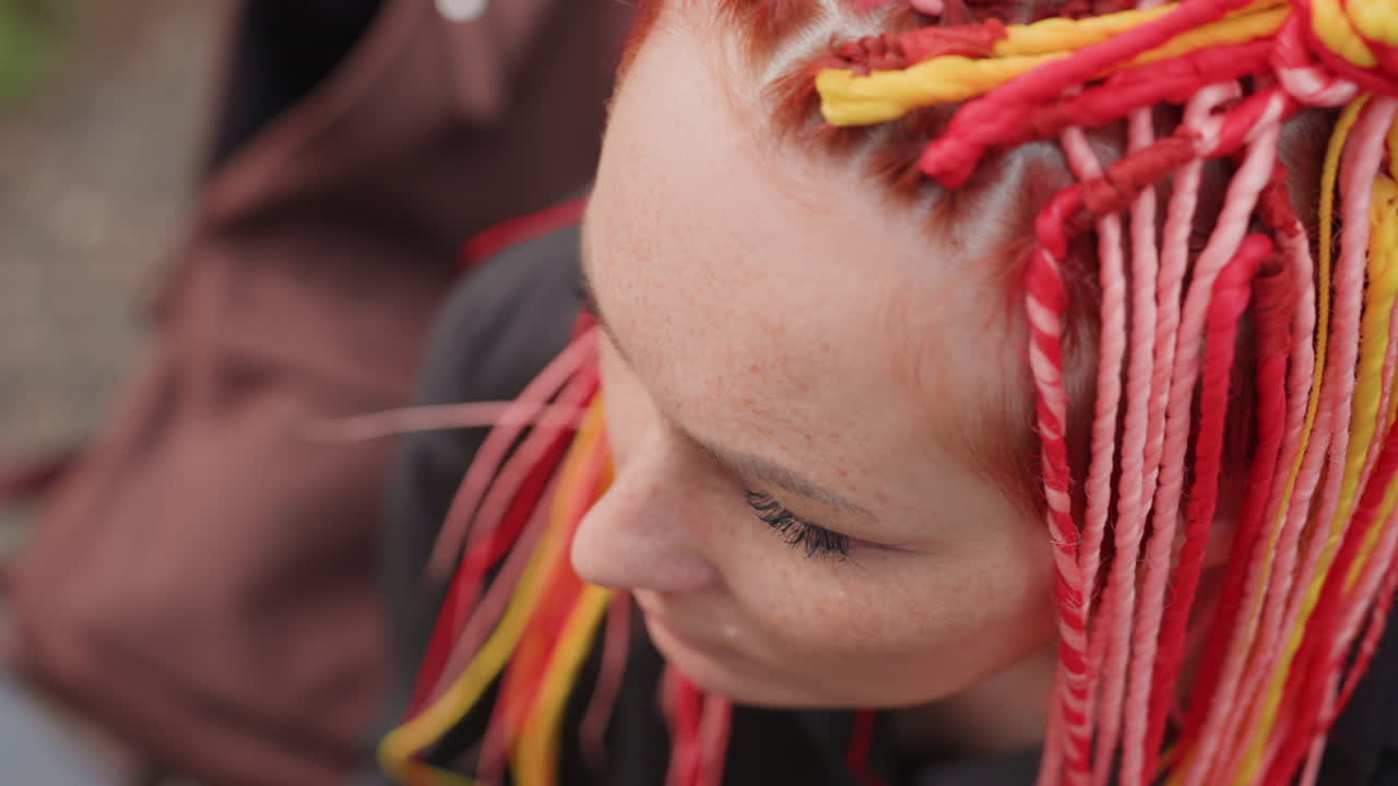 Una mujer con trenzas bebe de una botella; una mujer caucásica con las uñas pintadas bebe de un recipiente al aire libre; una mujer con trenzas multicolores levanta el tapón para beber de una botella de plástico en un parque.