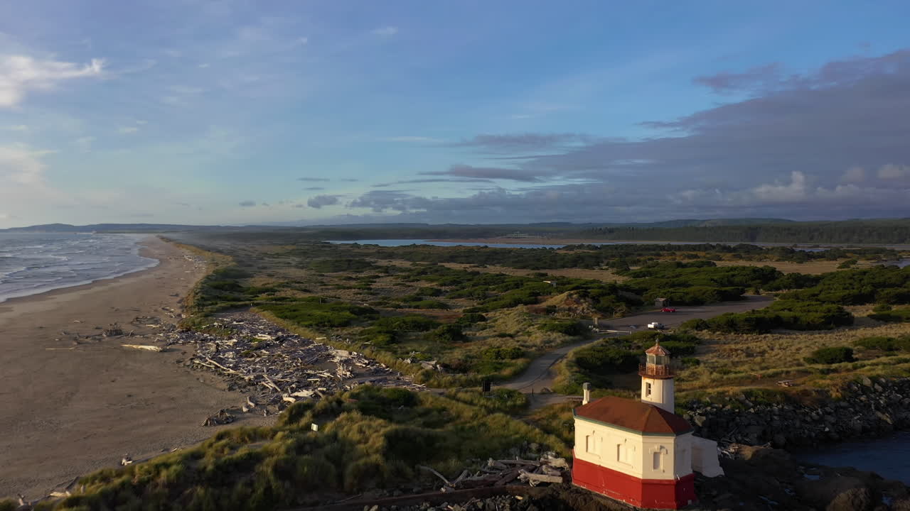 drone volando hacia el faro del río coquille y el parque estatal bullards beach en bandon oregon durante el día - toma aérea de drones