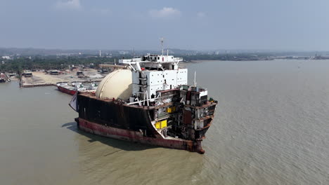revealing epic drone shot of a large ship abandoned in a ship graveyard in bangladesh