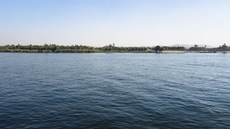 nile river flowing peacefully with the egyptian farmland in the background