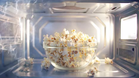 captivating transformation: witness the process of popcorn popping and filling a bowl in a microwave, showcasing the marvel of cooking in action.