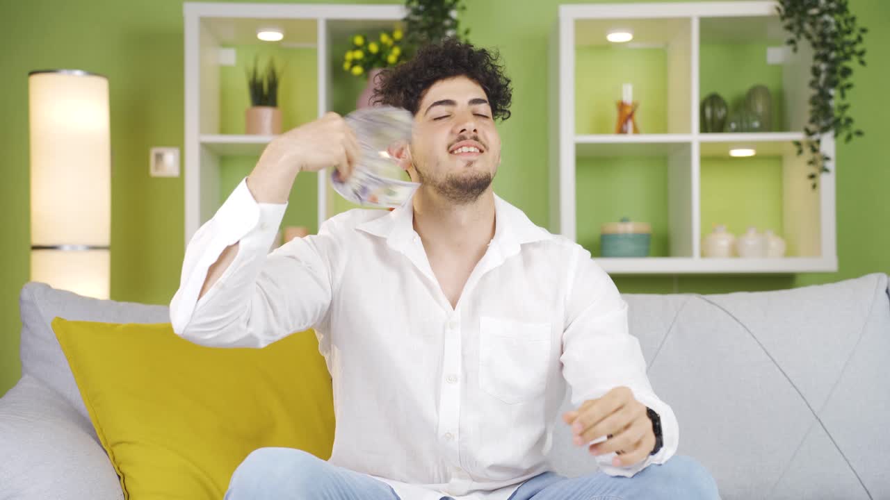 젊은이가 돈을 가지고 놀고 공중에 던지고 있습니다.