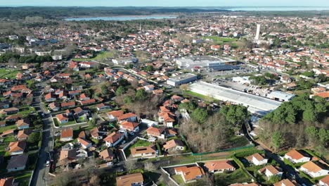 Residential-homes-among-industrial-warehouse-in-Biscarrosse-France-in-the-West-coast-of-Aquitaine,-Aerial-dolly-out-shot