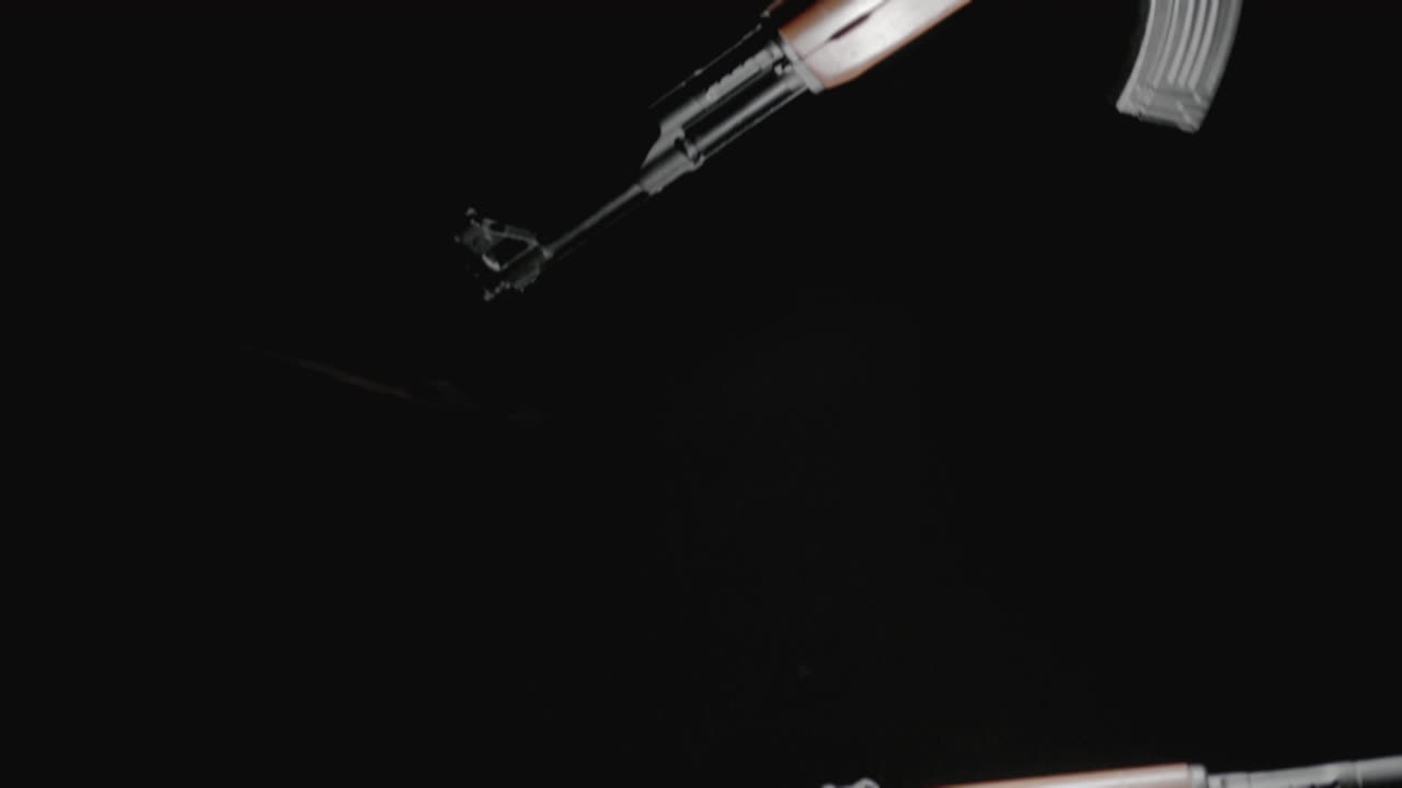 Machineguns on the dark background and in blinking lights are falling in slowmotion