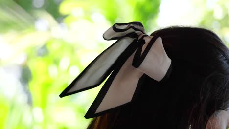 close-up of a ribbon in a woman's hair against a vibrant, sunlit background in phuket, thailand