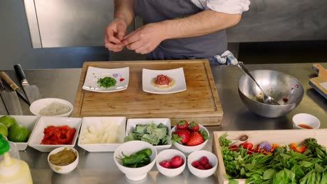 a man places garnish on a plate of food