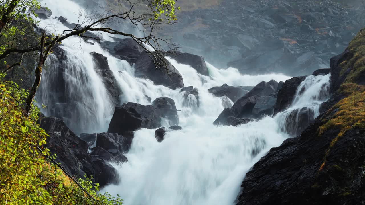 la cascada surge con una fuerza imparable, creando una atmósfera brumosa a medida que se sumerge en el desfiladero rocoso