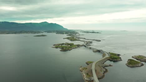 Aerial-pullback-above-winding-road-of-Atlanterhavsvegen-bridge-in-Nordmore,-Norway