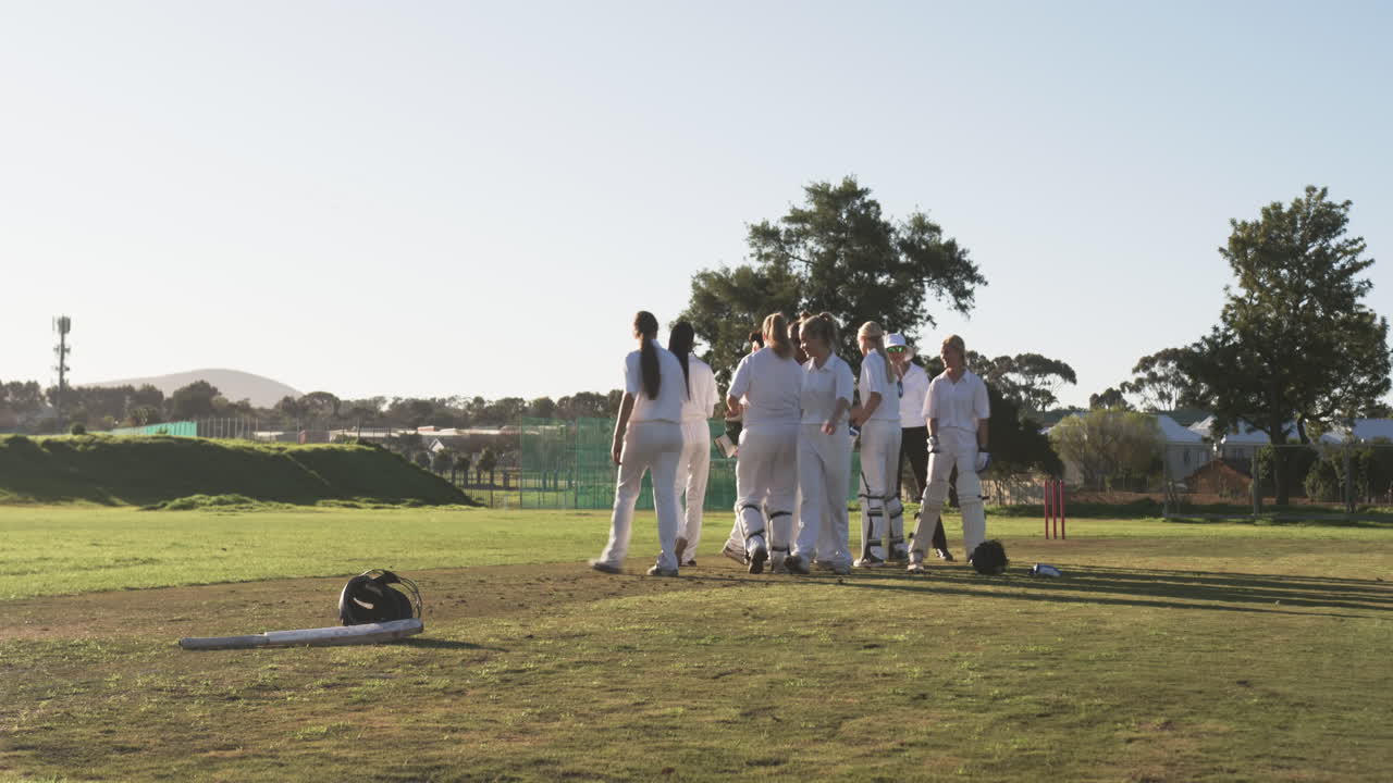 Female cricket team celebrating on field after winning match, enjoying victory