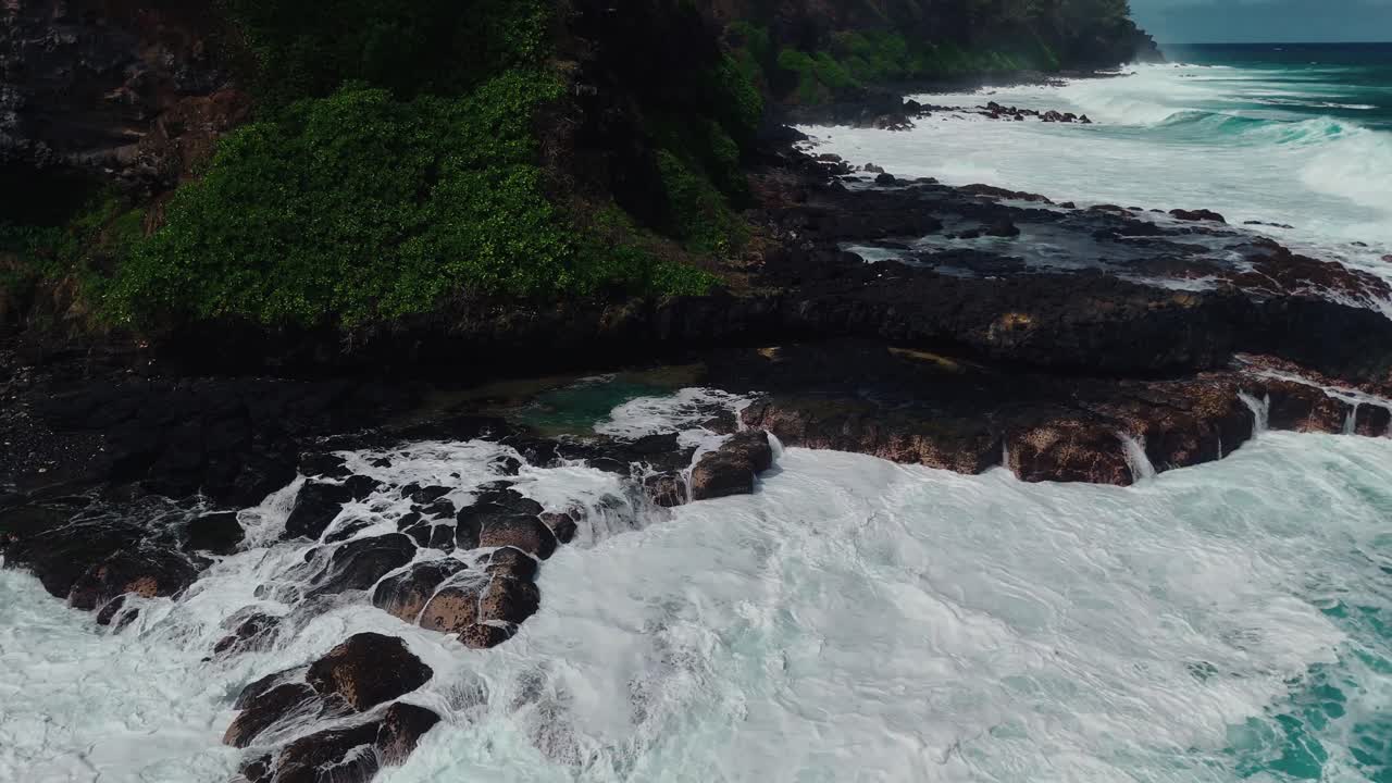 Waves crash dramatically against the rocky cliffs of Roche qui Pleure in Mauritius, showcasing rugged coastline, tropical scenery, and raw ocean power