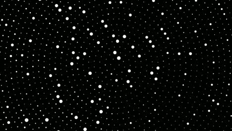 tiny radiant white dots moving on black background - closeup shot