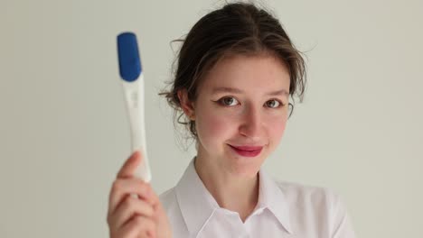 young woman holds pregnancy test