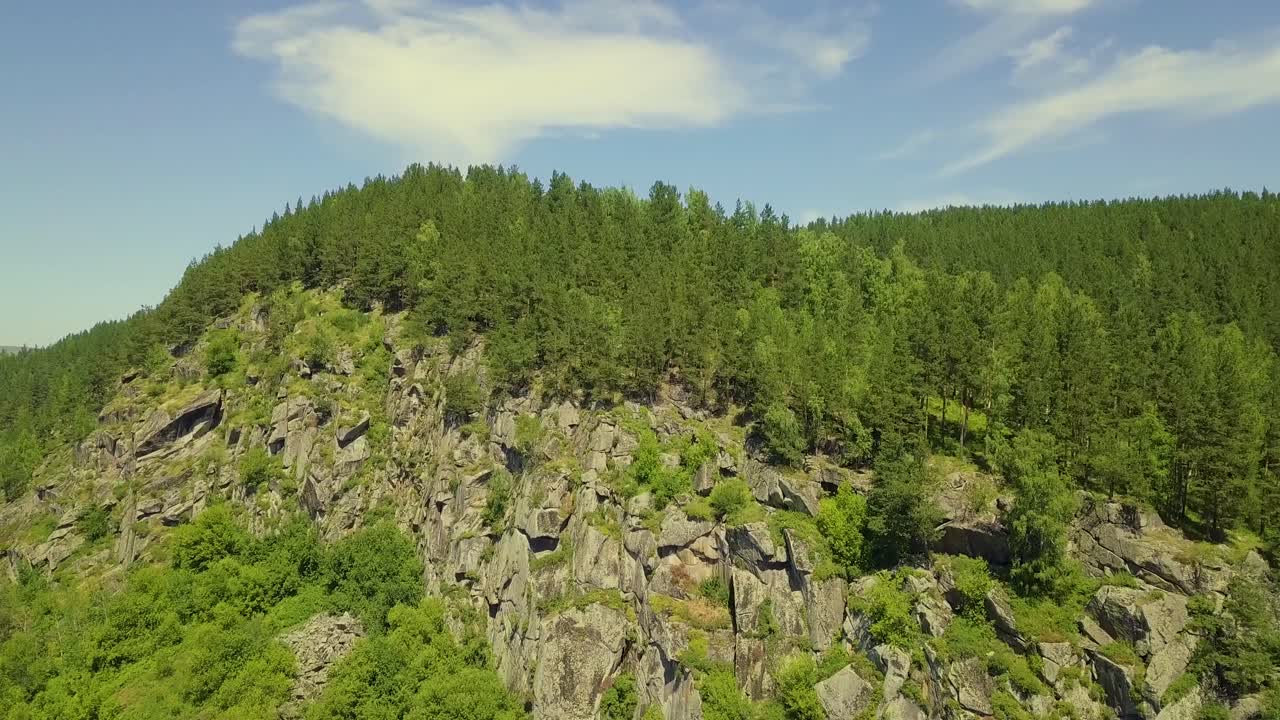 despegue aéreo sobre la montaña de piedra con bosque de coníferas