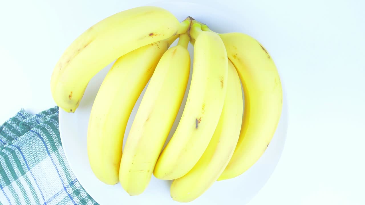 색 바탕에 있는 접시에 바나나. 음식. 과일. 비디오.