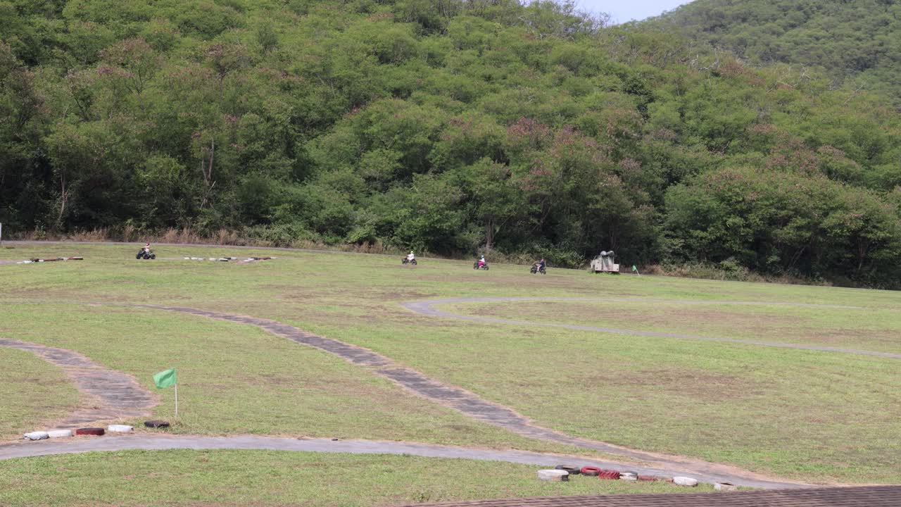 잔디을 가로질러 atv를 타고 다니는 개인