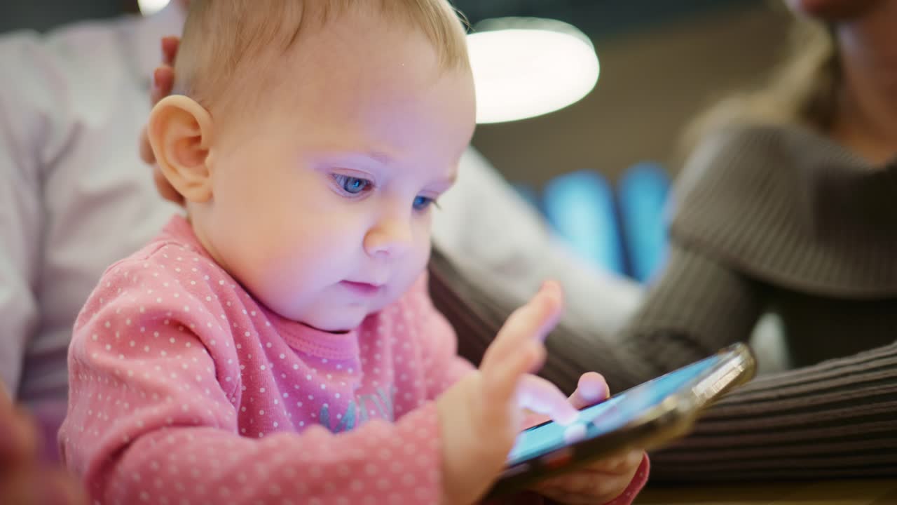 スマートフォンの画面を見つめる幼い女の子のクローズアップ