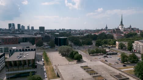 tallinn, estonia - ascending camera flight drone aerial bird view of the capital of estonia - panorama of old town of tallinn on the right and new business high rise district on the left baltic sea