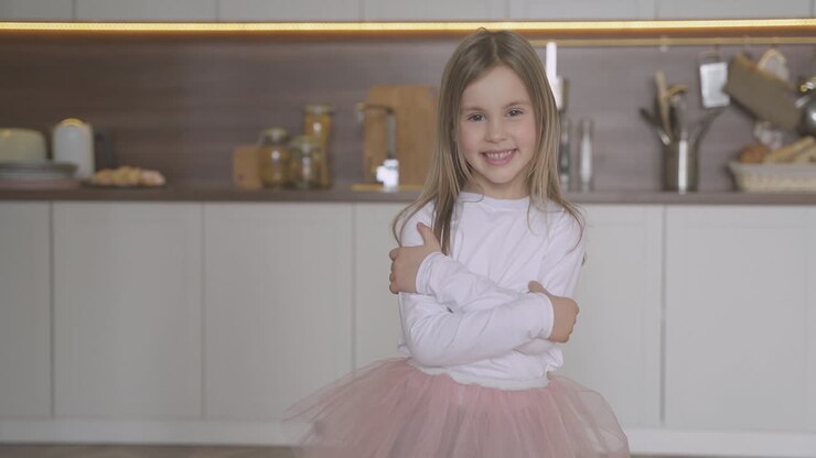 Niña feliz vestida de princesa posando en casa