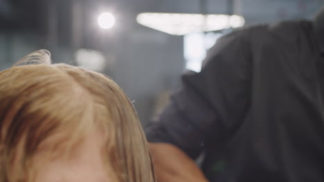 afro-american barber wetting and combing hair of client