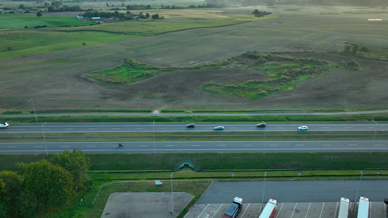 두 대의 차량이 지나가는 광활한 들판을 가로질러 가는 빈 도로의 드론