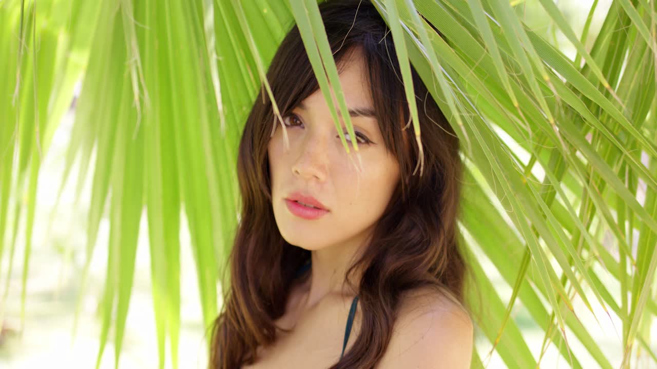 종려잎 그늘에서 수줍은 젊은 여자