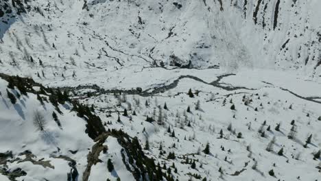 Aerial-view-of-a-creek-surrounded-by-snow-in-the-Austrian-Alps