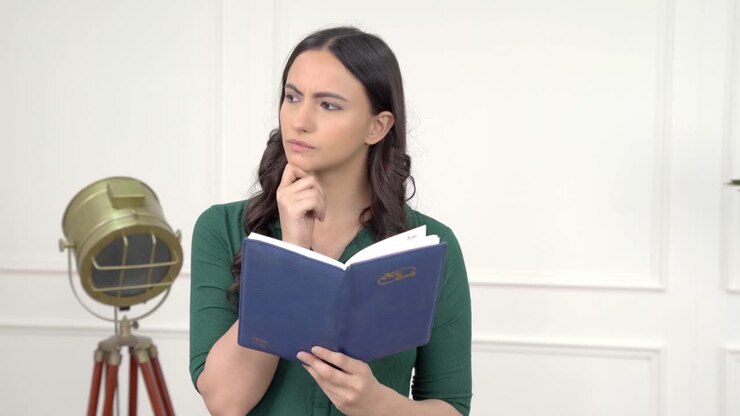 Donna indiana pensierosa che legge un libro