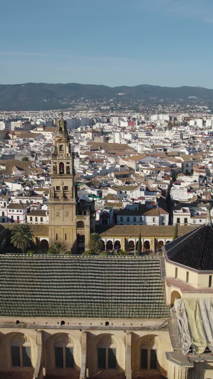 A Grande Mesquita de Córdoba, Espanha, revelando seus arcos icônicos, pátio e o centro histórico da cidade ao redor. Sobrevôo aéreo vertical.