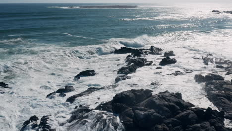 aerial view of foamy ocean waves crashing on the rocks at the beach in west coast national park, south africa - drone shot