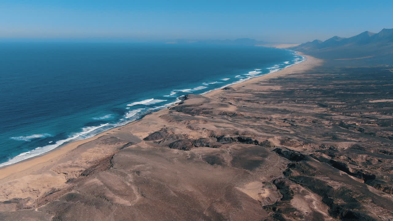 maravillosa toma aerea a gran altura sobre el parque natural de cofete en la isla de fuerteventura y donde se puede ver su fantastica playa y las hermosas montañas de la zona