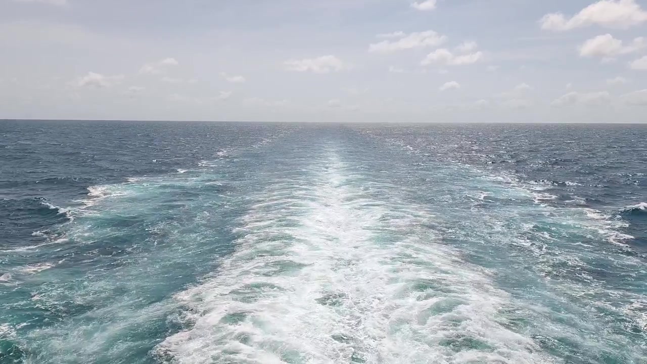 Ansicht der Heckwelle eines Schiffes, die sich über den blauen Ozean zieht