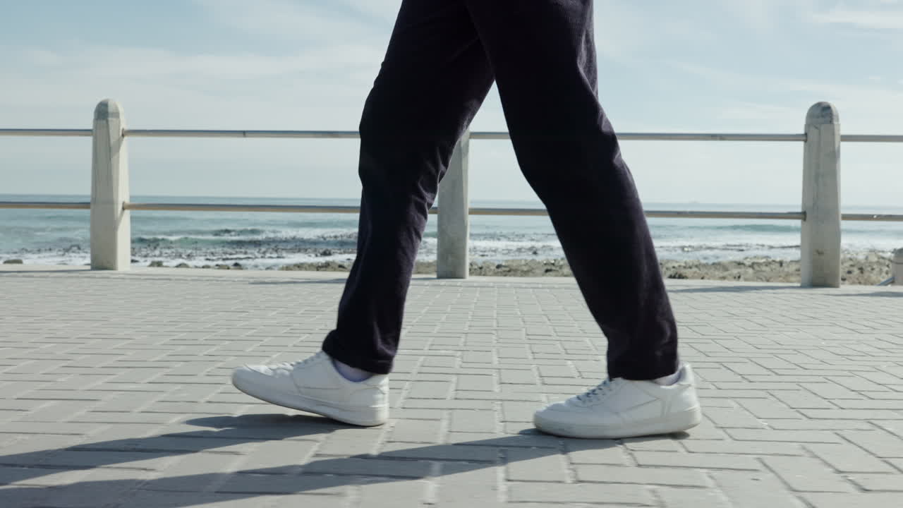 Person walking on a pathway near the ocean