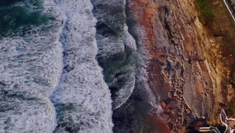 Drone-shot-of-some-waves-hitting-land