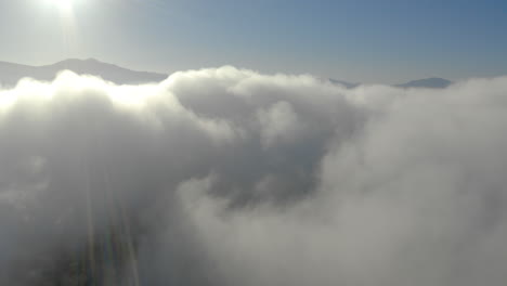 aerial view of low fog over mountains in san diego during sunrise