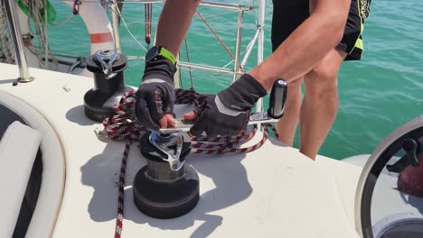 sailor working on yacht winch