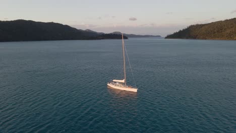 sailboat touring across hook passage at sunset