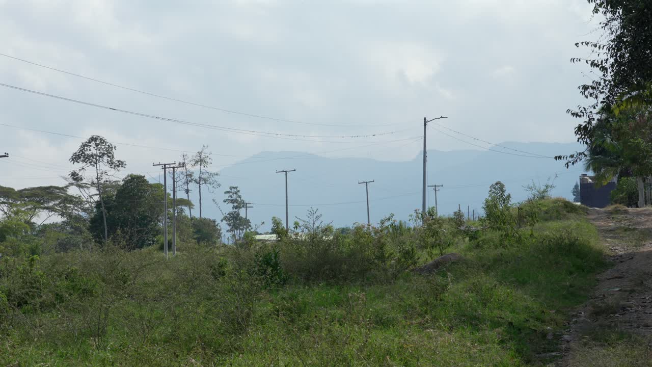 Rural landscape with hills mountains in the background overgrown grass Colombia village