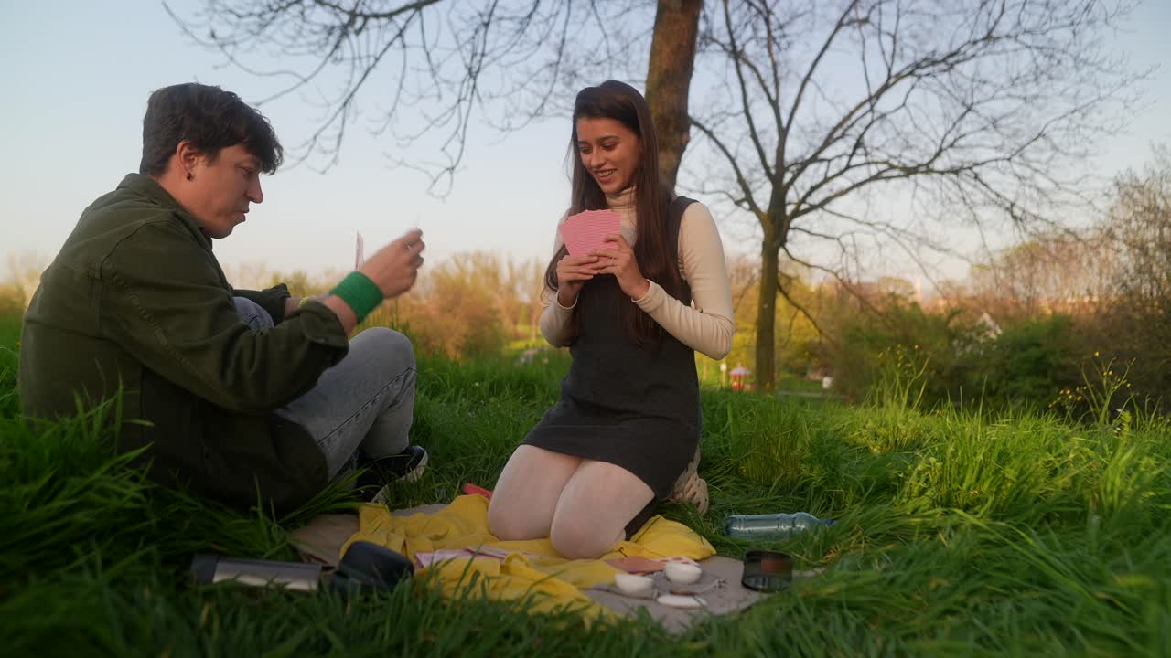 Couple Playing Cards in a Park