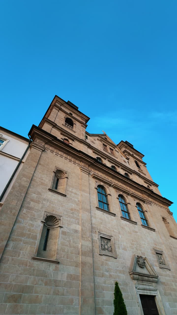 Old high building in the city street. Low angle view. Lots of people are walking by the paved road. Kosice, Slovakia. Vertical video.