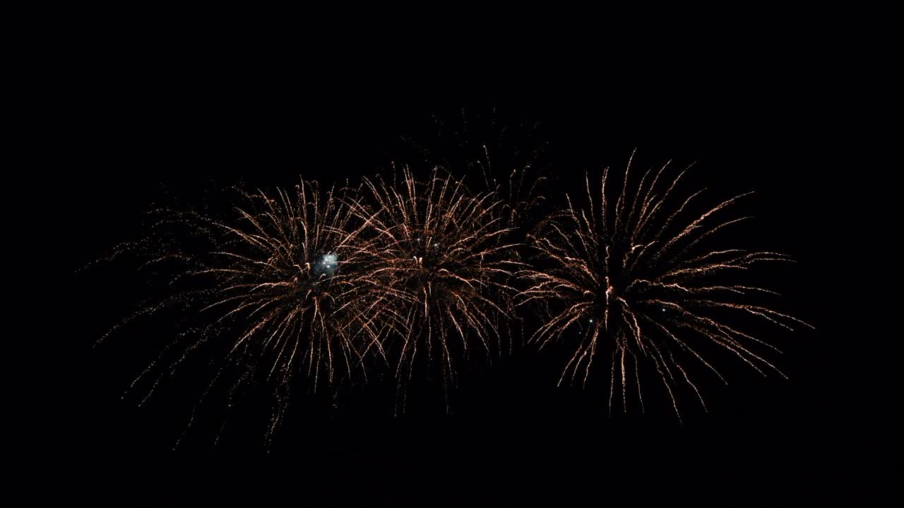 Loop seamless of real fireworks with abstract blur bokeh lights in night sky. Glowing fireworks festival. New year's eve 2022 fireworks celebration