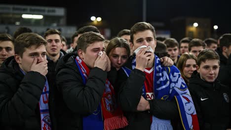 a heartfelt moment of emotions captured: young fans display mixed feelings of disappointment and support while attending a sports event in their team colors