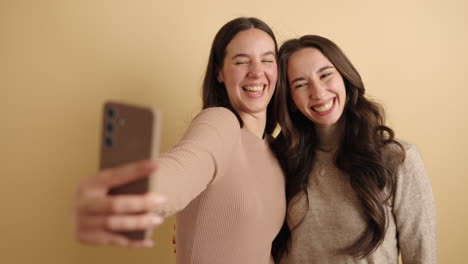 cheerful female friends taking selfie with smartphone