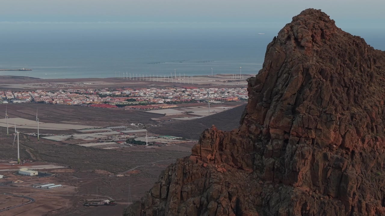 Aerial view of the Roque Aguayro natural monument with the coastal town and wind farm in the background on Gran Canaria island