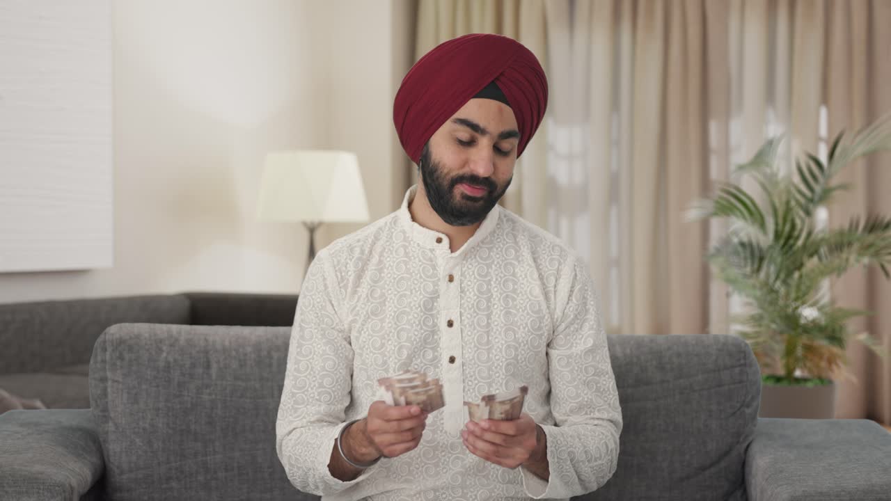 hombre indio sikh feliz contando dinero