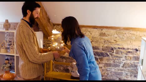 Man-showing-earthenware-lamp-to-a-woman