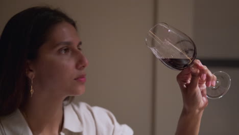 una mujer degustando vino rojo.
