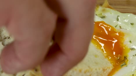 dipping whole wheat bread into fried egg yolk