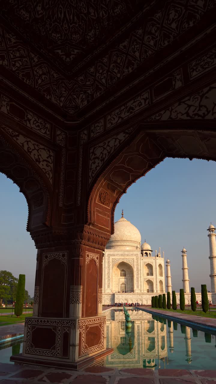 A low-angle video shot captures the Taj Mahal's reflection in the water, highlighting its grandeur