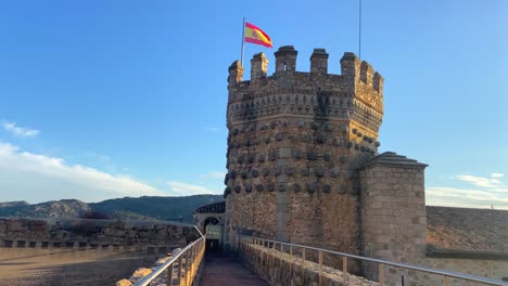 bandera española ondeando en el castillo medieval de mendoza en manzanares el real, españa