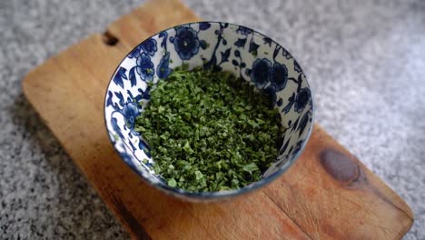 finely chopped parsley in a ceramic blue bowl